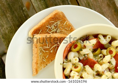 garlic bread and pasta salad on wood