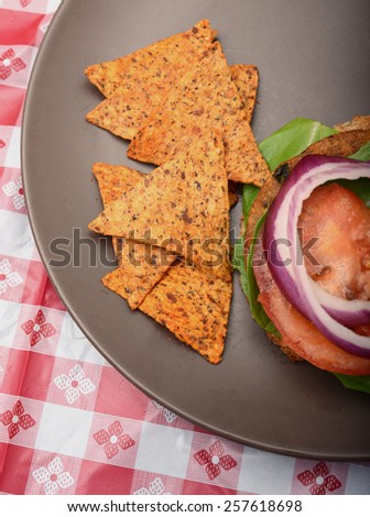 a vegan burger and whole grain chips at a barbecue