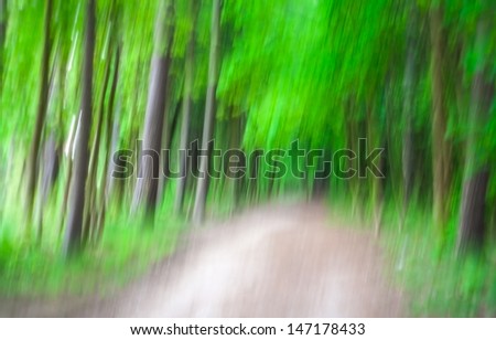 Blurred abstract in strong colors of the edge of a forest in spring