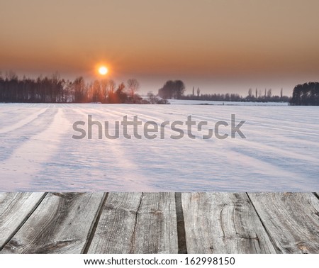 winter sunset over field. wood floor