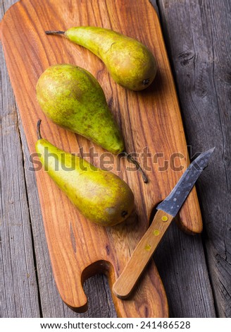 Long pears on wooden cutting board and ancient wooden table