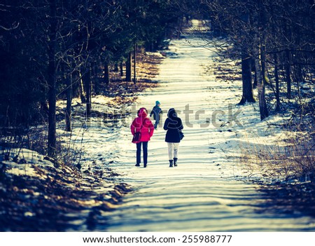 vintage photo of people walking in winter forest with child