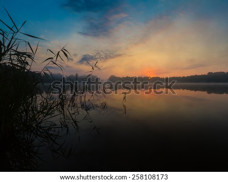 beautiful sunrise over foggy lake