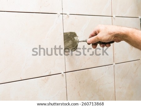 construction mason man hands on tiles work with cement mortar