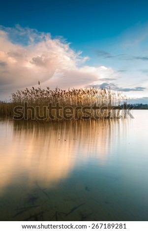 Beautiful sunset over calm lake in Mazury lake district. After sunset sky reflecting in water, calm vibrant landscape.