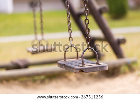 Empty swing on children playground in city.