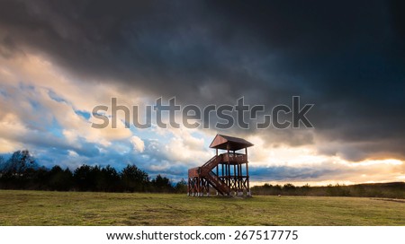 Beautiful landscape of watching tower under dramatic sky. Landscape with bad weather and vibrant colors.