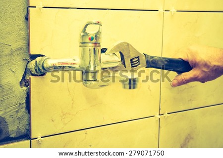 Vintage photo of plumbers hands tightening a water pipe. Authentic and accurate content depiction.