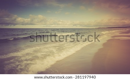 Vintage photo of beautiful beach landscape with cloudy sky and sea with waves. Baltic sea coast near Gdansk in Poland.