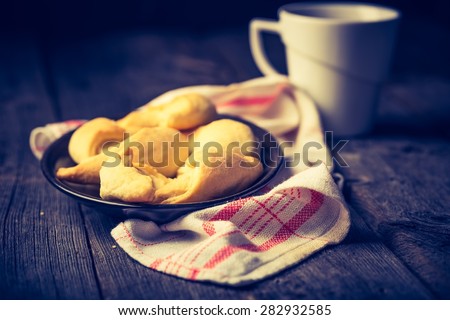 Homemade croissants and cup of tea on wooden table. Photo with vintage mood