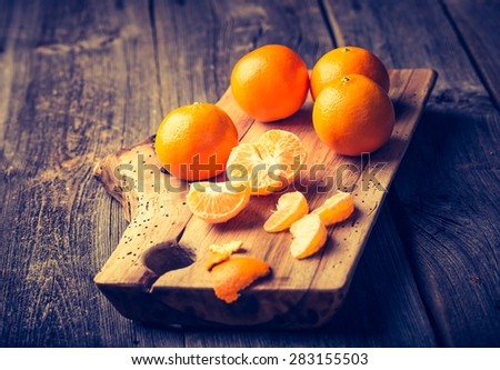 Vintage photo of fresh tangerines on wooden cutting board. Photo with old colors mood