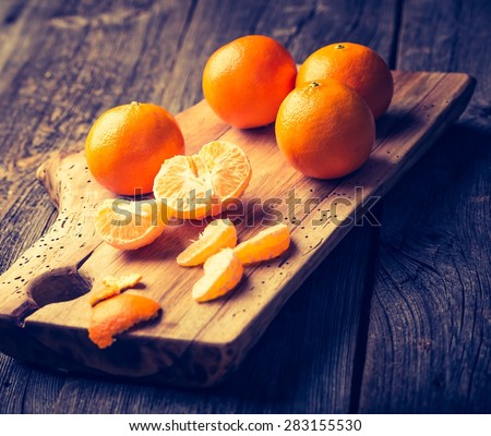 Vintage photo of fresh tangerines on wooden cutting board. Photo with old colors mood
