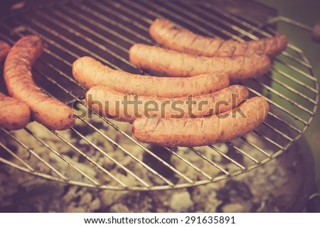 Vintage photo of grill with sausages. Grilling in outdoor - photo with vintage mood effect