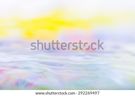 Moving water abstraction. Close up of water surface with colorful reflections