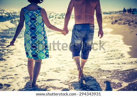 Couple walking by sea shore at daylight. Photo with vintage mood effect