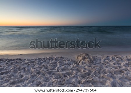 Beautiful Baltic sea beach at sunset. Beautiful seascape with sky reflected in water.