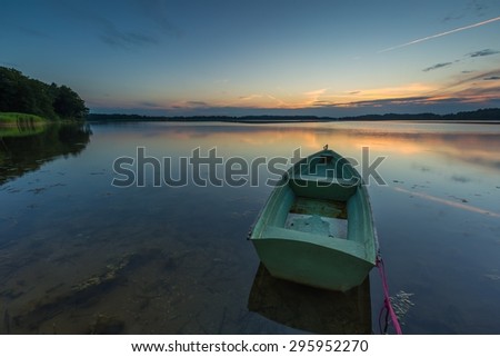 Beautiful lake sunset with fisherman boats. Polish lake in Mazury lake district. Polish lake landscape