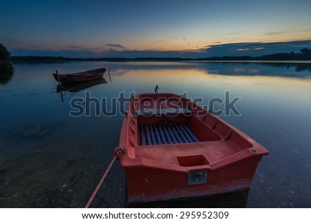Beautiful lake sunset with fisherman boats. Polish lake in Mazury lake district. Polish lake landscape