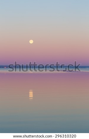 Beautiful before sunrise landscape of Gdanska Bay with setting moon photographed in Poland. Baltic sea shore.