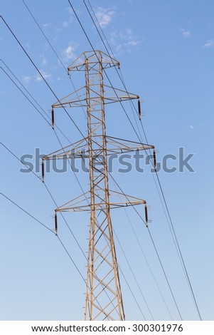 Power pole and power lines on blue sky background. Close up of power pole.
