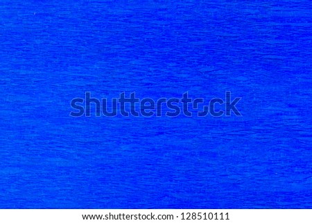 Macro detail of a blue pleated crepe paper in soft lighting