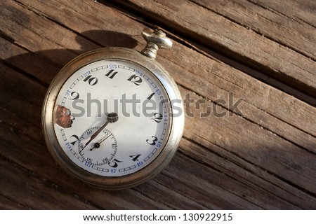 Old pocket watch on wooden background. Minute, time runs concept.