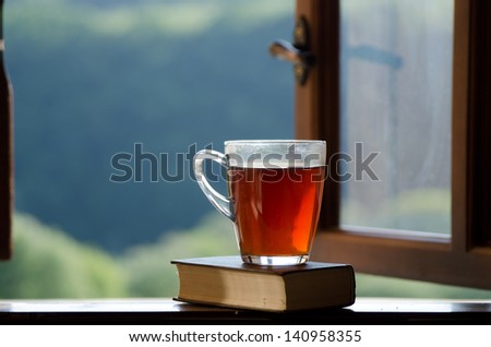 Cup of tea and book on window sill.