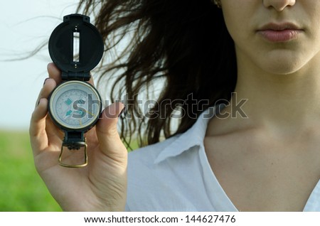 Concept find the right direction.Girl holding a compass.