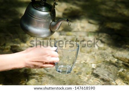 Pouring water from kettle. Clear water concept.