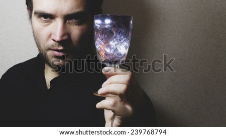 man holding wine glass, colored lights, play of light, focus on glass, retro toned