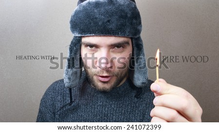 Heating With Firewood. Man hand holding a match. Firewood, heating concept. Russian style man.