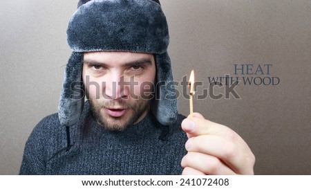 Heat with wood! Man hand holding a match. Firewood, heating concept. Russian style man.