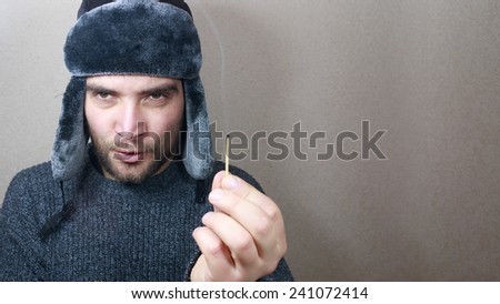 Man hand holding a match. Firewood, heating concept. Russian style man.