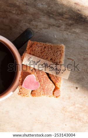 Cup of coffee on vintage wooden background and label  good morning