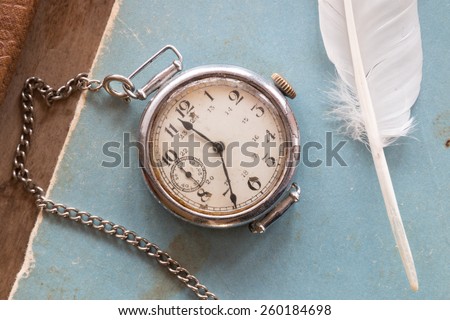 Retro background, old watches on a blue background and feather,  vintage.The Victorian era. Writer, literature, old school, polite learning concept.