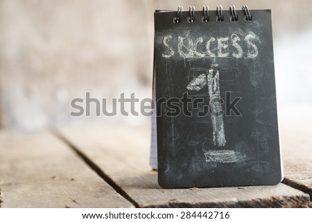 Success, first concept, chalk inscription and wooden table.