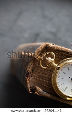 Vintage pocket watch and old book, symbols of time with copy space