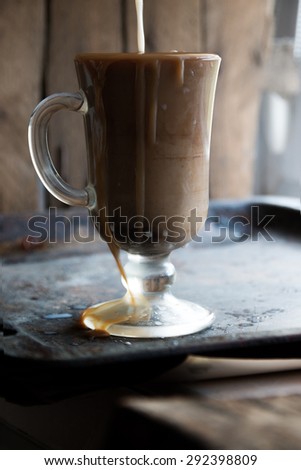 Coffee with milk, Pouring milk into coffee.