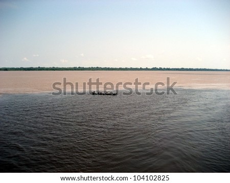 Meeting of the Rio Amaturá (black water) and the Rio Solimoes (muddy water) at Amaturá in the Amazon, Brazil