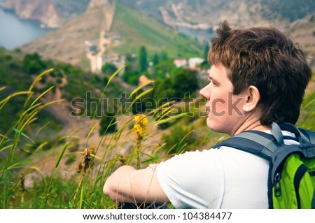 portrait of a young adult male tourist who rest sitting on mountains