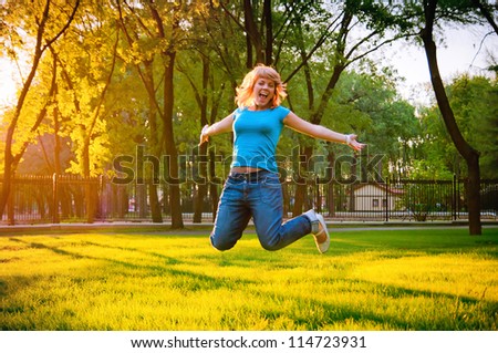 cheerful young girl jumping in the park