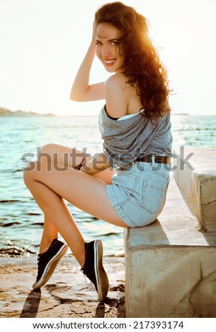young beautiful smiling girl on a background of sea and sun