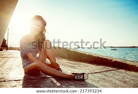 young beautiful smiling girl on a background of sea and sun