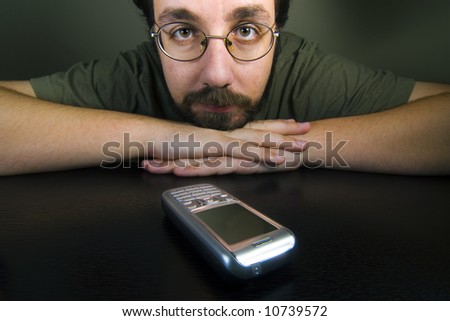 man waiting for a call while the mobile is in the table
