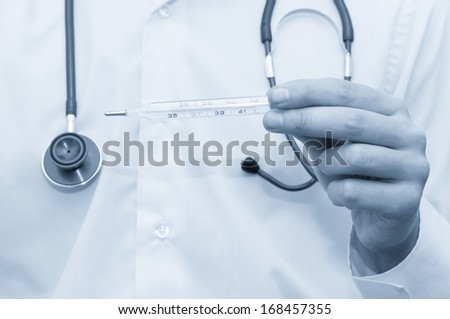 Close-up of doctor\'s hands with thermometer, taking temperature