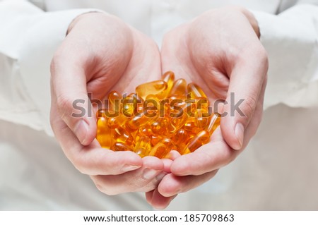 Doctor's hand with gel capsules. Vitamin Omega-3 fish oil