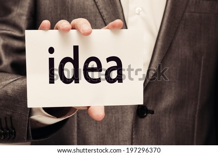 Businessman showing a card with word Idea written on it