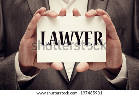 Lawyer. A man wearing a suit holding a signboard with the word lawyer written in it