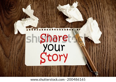 Share your story written on the paper on a wood background