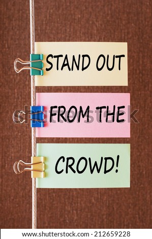 Stand out from the crowd concept. Business message text wording on colorful note papers on a rope